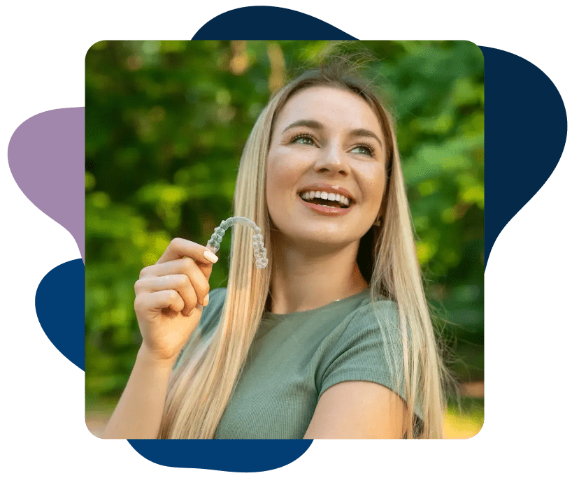Smiling girl holds Invisalign clear braces
